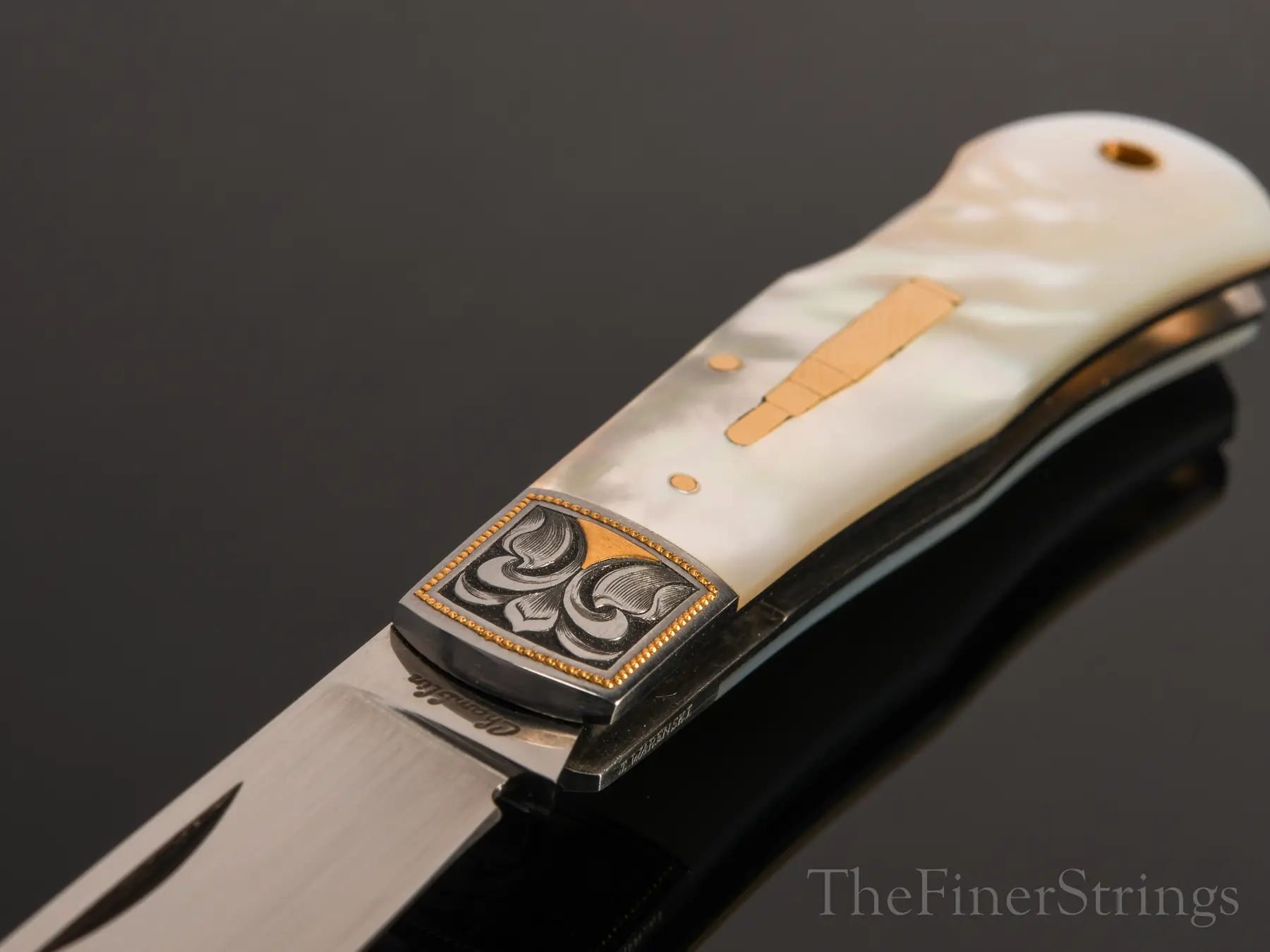 Bolster detail — gold bead border and scroll engraving