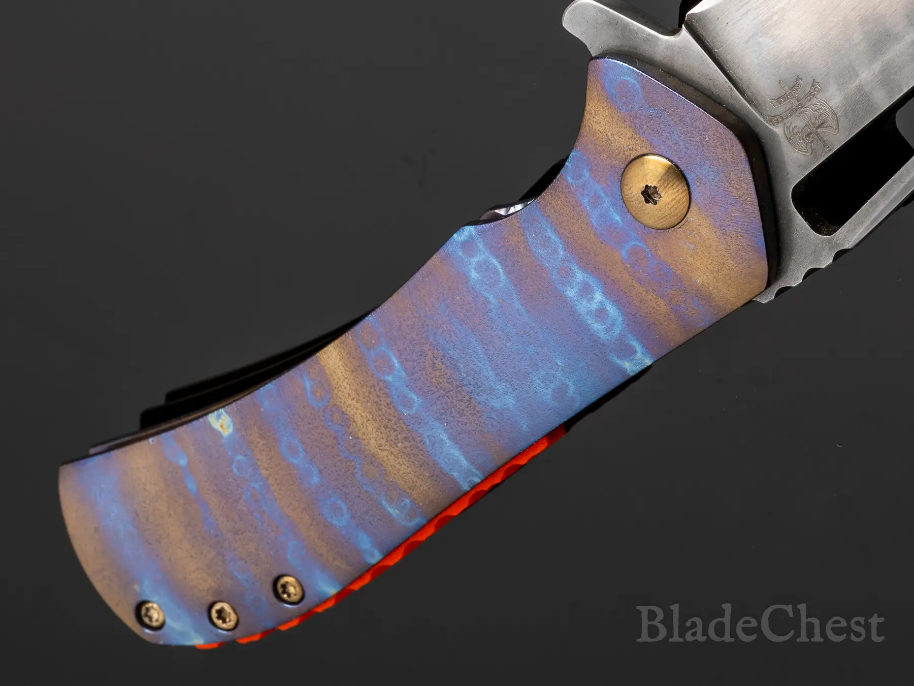 Flamed titanium handle — orange G10 detail
